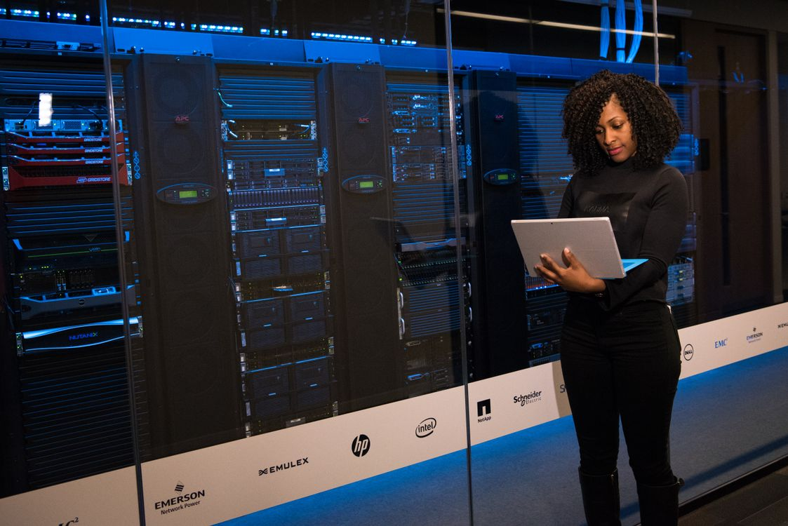 Professional reviewing a tablet beside secure server racks