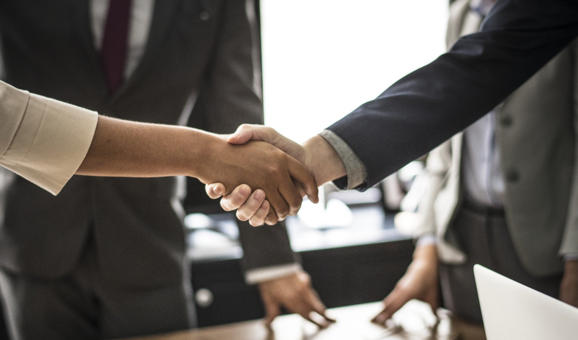 Business professionals shaking hands across a table