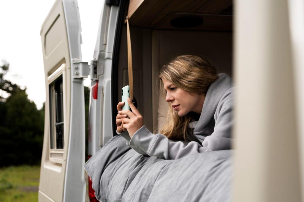 Traveler relaxing in the doorway of an RV during a road trip